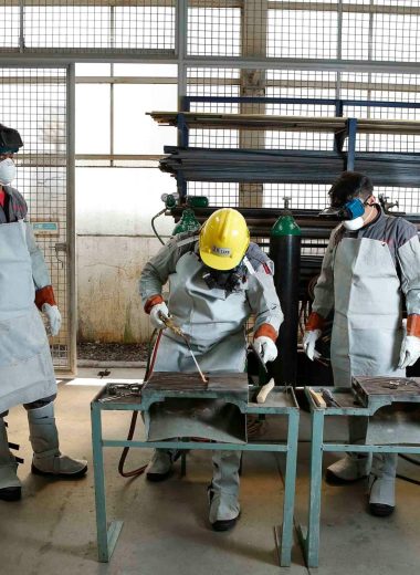 Group of workers in protective gear engaged in factory training in the Philippines.